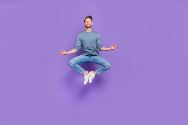 Zdjęcie uroczy marzycielski facet ubrany szara koszula skoków wysokie ćwiczenia jogi odizolowane fioletowy kolor tła — Zdjęcie stockowe