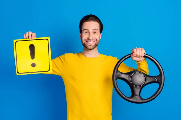 Retrato de atractivo chico alegre sosteniendo el tablero del cartel del volante aislado sobre fondo de color azul brillante —  Fotos de Stock