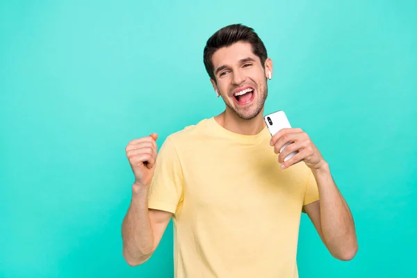 Foto van koele brunet millennial guy zingen telefoon slijtage t-shirt hoofdtelefoon geïsoleerd op teal kleur achtergrond — Stockfoto