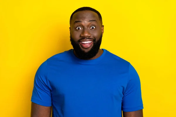 Portrét atraktivní veselý užaslý chlap na sobě modré tričko dobré zprávy reakce izolované přes jasně žluté barvy pozadí — Stock fotografie