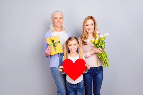 Портрет трех позитивных веселой женщины держать сердечную карту подарочную коробку цветы изолированы на сером фоне цвета — стоковое фото