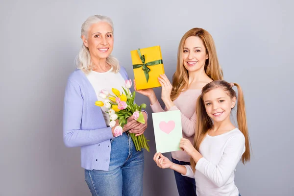 Портрет трех дружественных мирных людей поздравляют держать открытки цветы изолированы на сером фоне цвета — стоковое фото