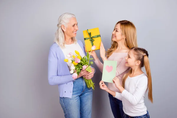 Foto di tre belle persone danno ricevere occasione giftbox fiori isolati su sfondo di colore grigio — Foto Stock