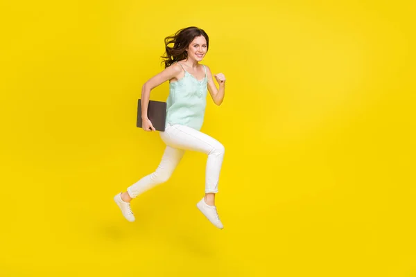 Foto de cuerpo completo de mujer positiva enérgica corriendo a trabajar con netbook aislado sobre fondo de color amarillo —  Fotos de Stock