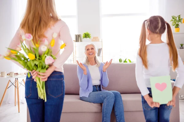 Портрет трех человек пользуются женщина день спрятать букет цветов за задней гостиной в помещении — стоковое фото