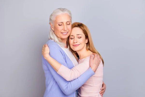 Retrato de dos encantadoras mujeres ojos cerrados abrazo aislado sobre fondo de color gris pastel —  Fotos de Stock