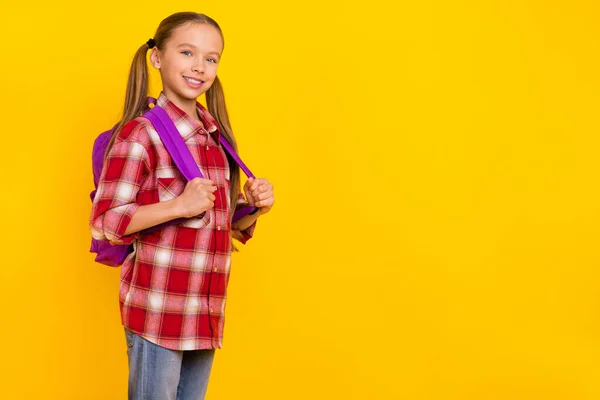 Çok sevimli bir okul çocuğunun resmi ekose gömlekli, yürüyen kollu, boş, izole edilmiş sarı arka plan. — Stok fotoğraf