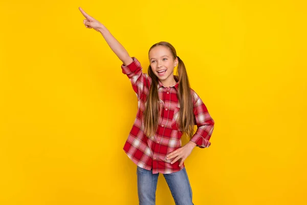 Foto de lindo colegial emocionado vestido camisa a cuadros bailando apuntando espacio vacío aislado color amarillo fondo —  Fotos de Stock
