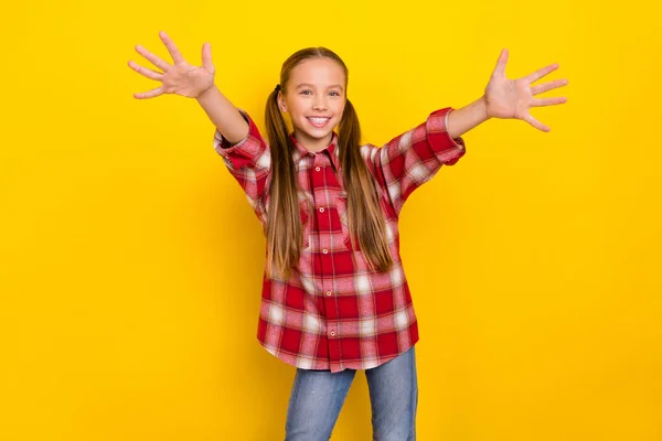 Fénykép a bájos lenyűgözött iskolás lány viselni kockás ing kész átölel nyitott karok elszigetelt sárga háttér — Stock Fotó