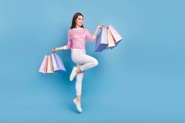 Full length photo of glad lady hold packages look empty space offer isolated on blue color background — ストック写真