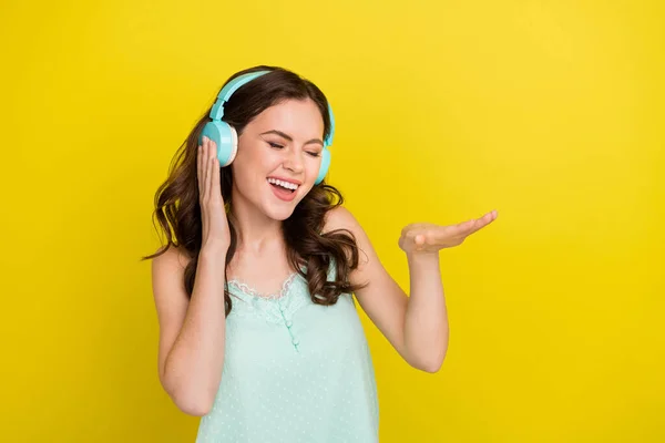 Foto von charmanten netten aufgeregten Frau hören coole Rap-Musik in Kopfhörern isoliert auf gelbem Hintergrund — Stockfoto