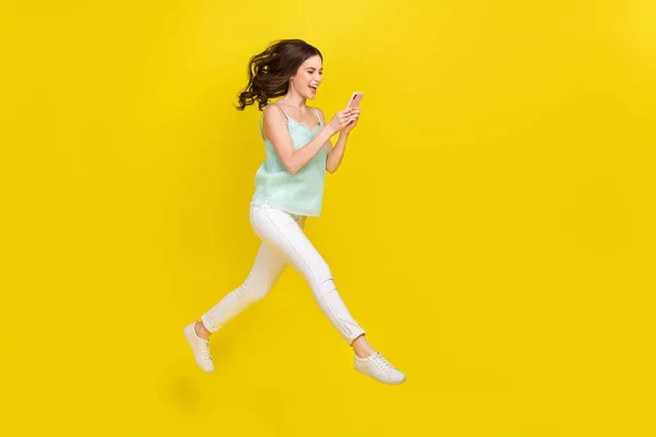 Full length profil boční fotografie roztomilé okouzlující příležitostné oblečení dívka surfování sociální média izolované na žluté barvy pozadí — Stock fotografie