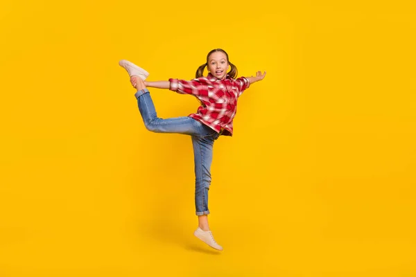 Çok sevimli bir okul çocuğunun ekose gömlekli fotoğrafı yüksekten atlıyor jimnastik yapıyor izole edilmiş sarı arka plan — Stok fotoğraf
