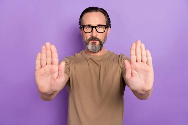 Photo de l'homme de l'émotion stricte grave montrant geste d'arrêt vous demander de reculer isolé sur fond de couleur violette — Photo