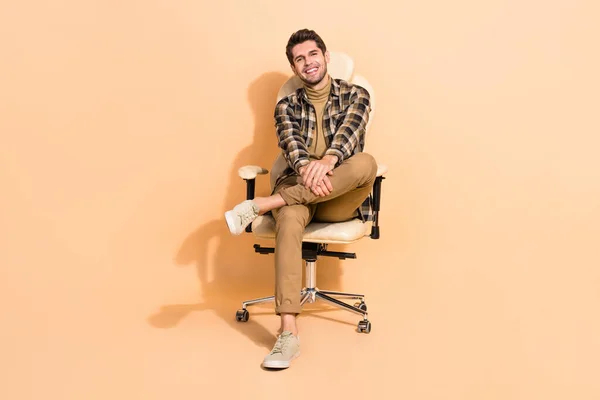 Retrato de cara confiante alegre atraente sentado em cadeira experiência especializada isolado sobre fundo cor pastel bege — Fotografia de Stock