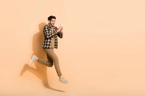Full size profiel side photo of excited guy jump up run zoeken eshop korting apparaat geïsoleerde pastel kleur achtergrond — Stockfoto