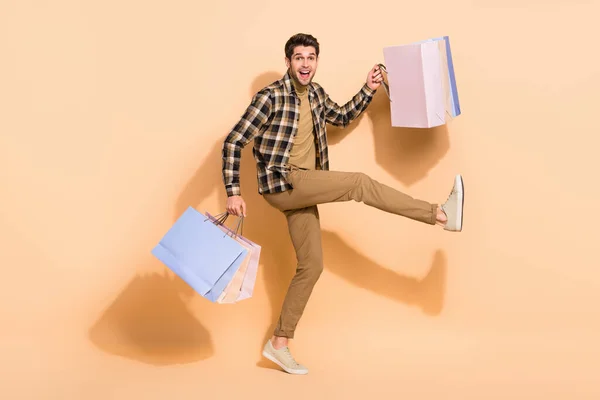 Full size foto van vrolijke jongen houden pakketten gekocht op lage prijs suggestie verrassing geïsoleerde pastel kleur achtergrond — Stockfoto