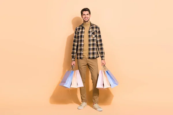 Full body foto van positieve jongen houden veel pakketten gekocht specials biedt winkels geïsoleerde pastel kleur achtergrond — Stockfoto