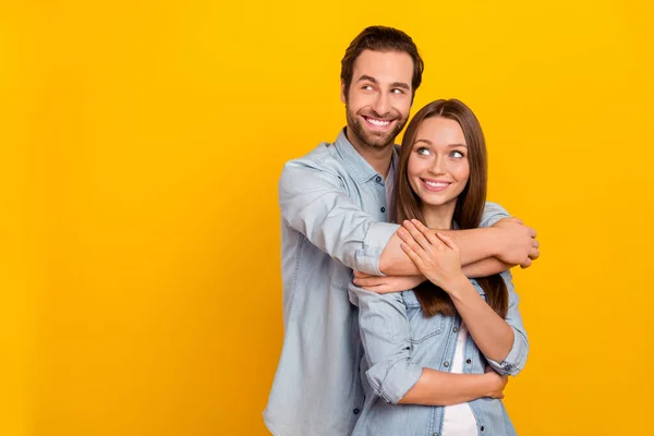 Portret van aantrekkelijke vrolijke dromerige paar knuffelen uitziende idee kopiëren ruimte geïsoleerd over helder gele kleur achtergrond — Stockfoto