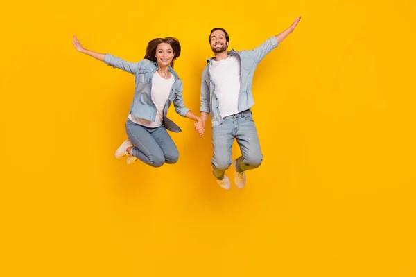 Volledige lichaamsomvang uitzicht van aantrekkelijke vrolijke mensen springen reis geïsoleerd over helder gele kleur achtergrond — Stockfoto