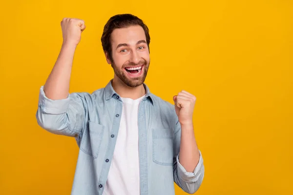 Foto de hooray jovem penteado marrom cara gritar usar camisas jeans isoladas no fundo amarelo — Fotografia de Stock