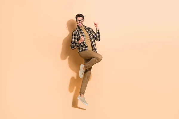 Longitud completa cuerpo tamaño vista de atractivo alegre chico saltando bailando divertirse aislado en beige pastel color fondo —  Fotos de Stock