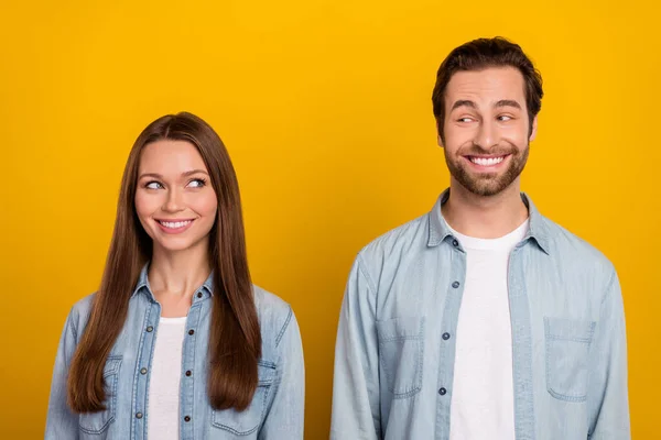 Φωτογραφία του δύσκολου αστεία σύζυγος φορούν τζιν πουκάμισα κοιτάζοντας ο ένας τον άλλον μάτια απομονωμένο κίτρινο χρώμα φόντο — Φωτογραφία Αρχείου