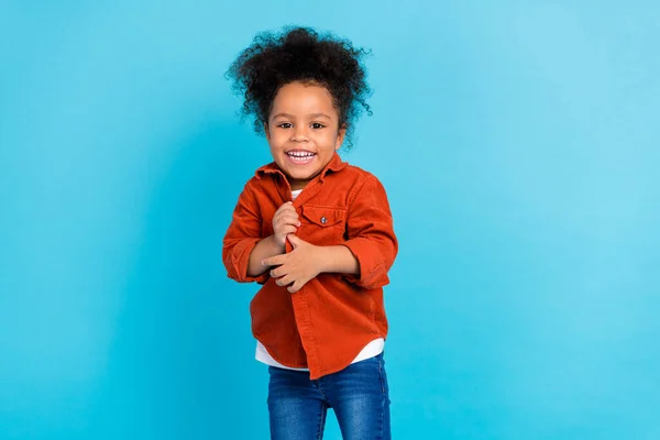 Фото милая кудрявая маленькая девочка носить рубашку джинсы изолированы на синем фоне цвета — стоковое фото