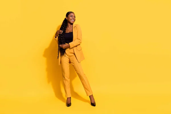 Foto em tamanho completo de engraçado millennial senhora stand olhar promo desgaste terno saltos altos isolados no fundo amarelo — Fotografia de Stock