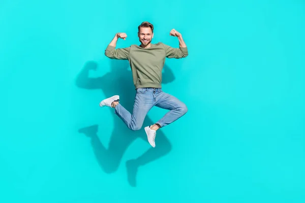 Foto de perfil de longitud completa de confiado deportista fuerte salto mostrar bíceps desgaste jersey aislado fondo de color azul —  Fotos de Stock