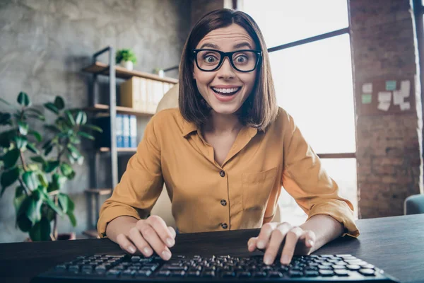 Photo of surprised cheerful person sit chair keyboard writing networking look camera office building inside — Stock Photo, Image