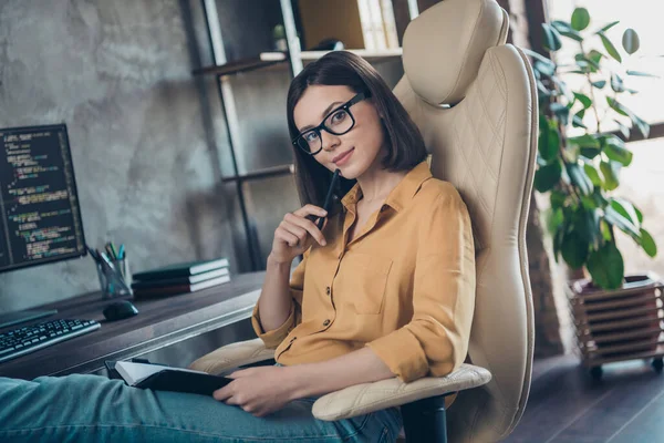 正面迷人的女经理的画像坐在椅子上笔触下巴看着里面的相机办公大楼 — 图库照片