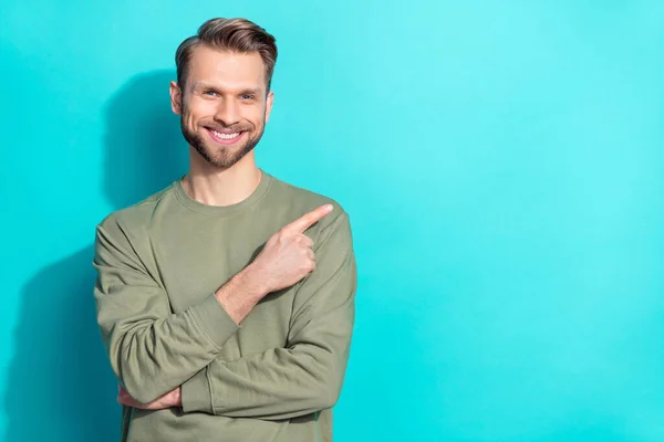 Foto de alegre promotor confiado hombre dedo directo espacio vacío desgaste jersey aislado color azul fondo — Foto de Stock