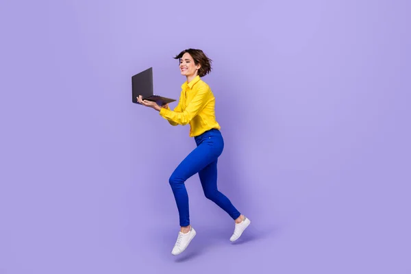 Foto de perfil em tamanho completo de jovem morena funky executada com laptop desgaste calças de camisa sapatos isolados no fundo roxo — Fotografia de Stock