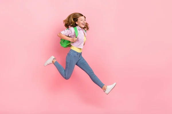 精力的な女性のプロフィール写真ジャンプ実行ショッピング急いでコンセプトは、バックパックジャケット孤立ピンク色の背景を身に着けている — ストック写真