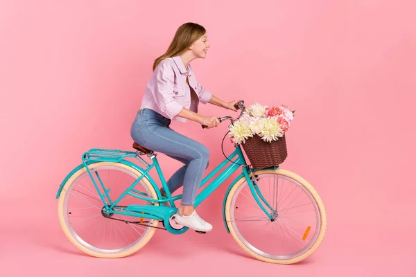 Perfil foto de senhora alegre passeio de bicicleta entregar flores pressa compras conceito desgaste casaco isolado cor-de-rosa fundo — Fotografia de Stock