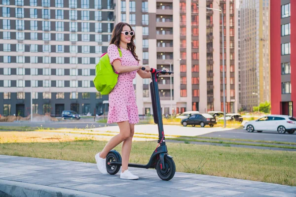 Full length body size view of attractive cheerful girl riding scooter enjoying trip tour strolling outdoors — ストック写真