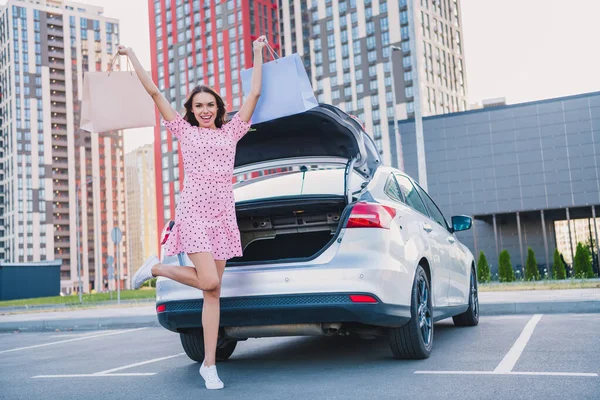 Pleine longueur photo de la jeune femme excitée magasin debout près de véhicule automobile se réjouir réduction temps libre en plein air — Photo