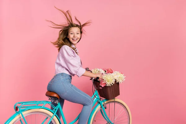 Foto de surpreendido senhora drive bicicleta vento sopro cabelo dente sorriso desgaste casaco isolado cor-de-rosa fundo — Fotografia de Stock