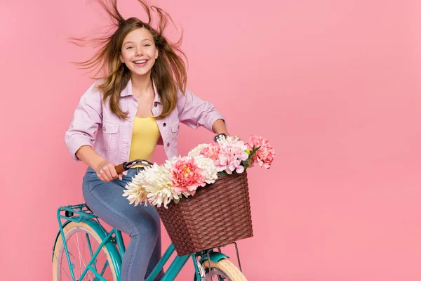 Foto de alegre encantador senhora conduzir bicicleta vento cabelo desgaste casaco isolado cor-de-rosa fundo — Fotografia de Stock