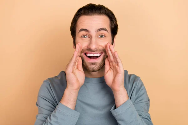 Photo of young excited guy arms near mouth yell advertising discount isolated over beige color background — ストック写真