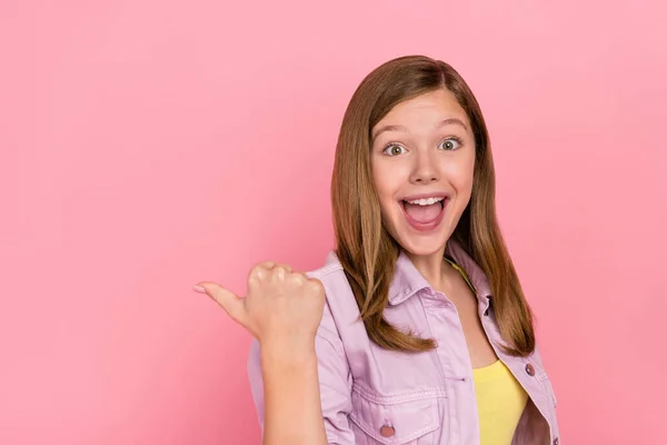 Profil strona zdjęcie młodej podekscytowanej dziewczyny punkt kciuk pusty przestrzeń propozycja zniżki izolowane na różowy kolor tła — Zdjęcie stockowe