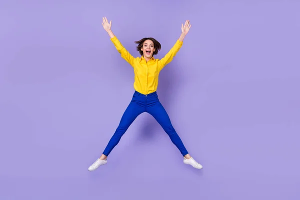フルボディ写真のhooray若い女性ジャンプ身に着けていますスマートカジュアル絶縁上の紫の背景 — ストック写真