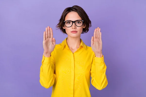 Foto van strenge duizendjarige dame handpalmen dragen gele outfit bril geïsoleerd op violette kleur achtergrond — Stockfoto