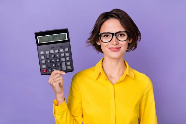 Foto de smart millennial lady hold calculadora use gafas de traje amarillo aisladas sobre fondo de color violeta —  Fotos de Stock