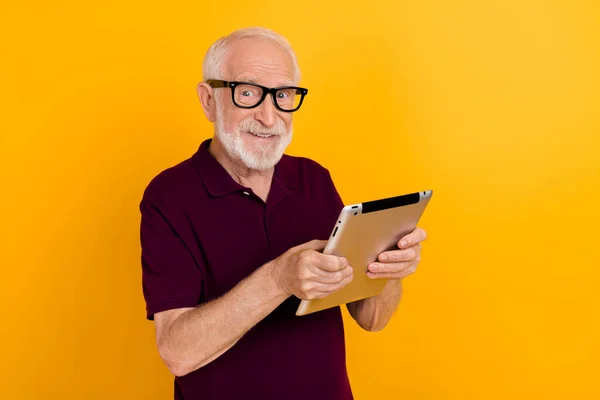 Foto de homem alegre maduro bate-papo tipo de mídia social aplicativo tablet download isolado sobre fundo de cor amarela — Fotografia de Stock