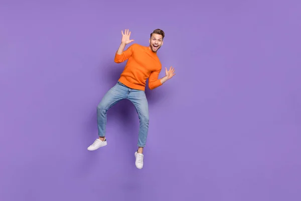 In voller Länge Foto von guter Laune überglücklichen Mann springen Welle Hände sagen hallo treffen Freund isoliert auf violettem Hintergrund — Stockfoto