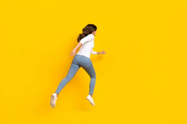 Foto von ziemlich aufgeregt Dame gekleidet weißes Hemd läuft schnell springen hohe isolierte gelbe Farbe Hintergrund — Stockfoto
