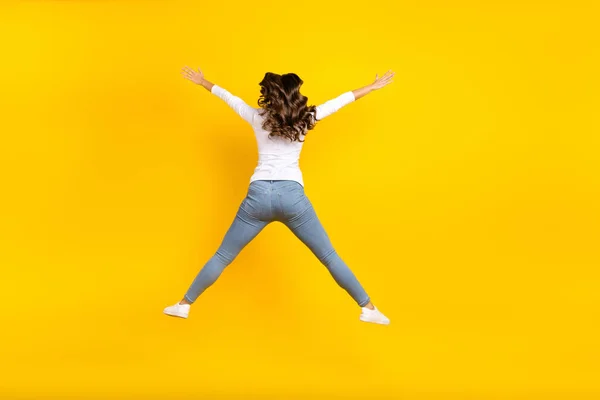 Foto de mujer funky brillante usar camisa blanca saltando alto como la estrella aislada de color amarillo de fondo — Foto de Stock