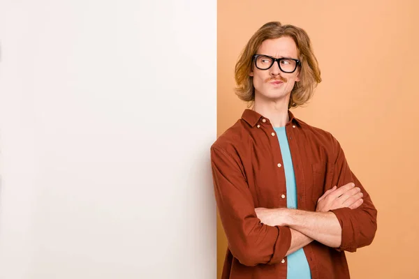 Porträtt av attraktiva sinnade smart rödhårig kille vikta armar kopiera tomt utrymme isolerad över beige pastell färg bakgrund — Stockfoto